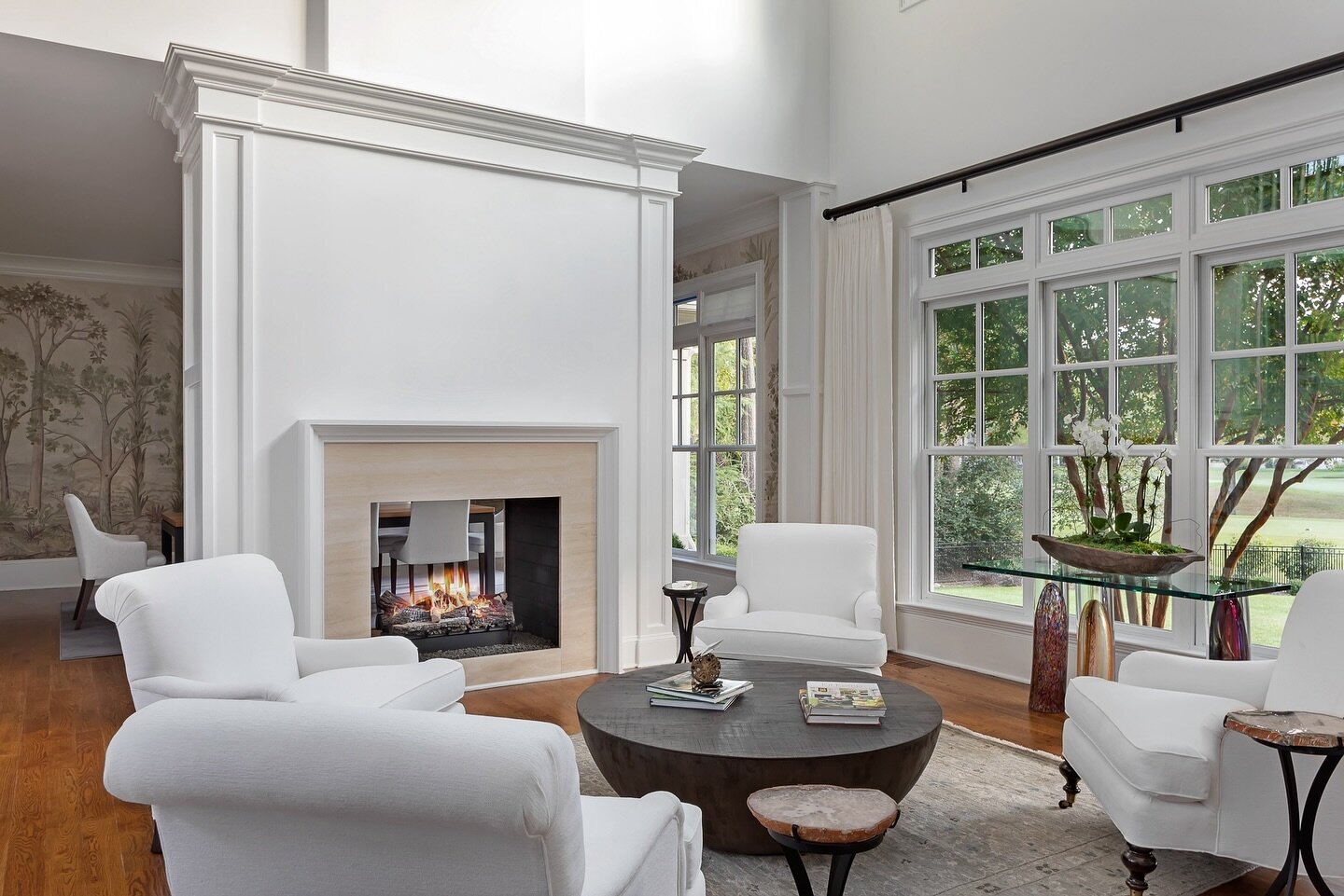 Happy Friday! Our clients enjoy cozy nights in and gatherings around this double-sided fireplace which adds warmth and a stunning centerpiece shared between two spaces simultaneously. This living room was designed to seamlessly blend comfort with ele