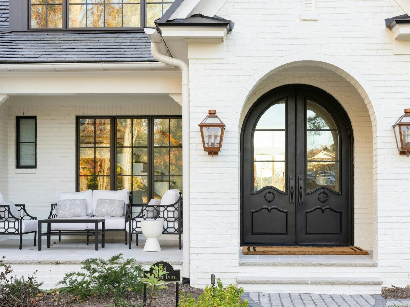 With a traditional silhouette and subtle old-world influence, we brought our client's vision to life with faux slate shingles, round gutters, custom brackets, and an arched front door designed alongside our client's daughter. Topped with a private ob