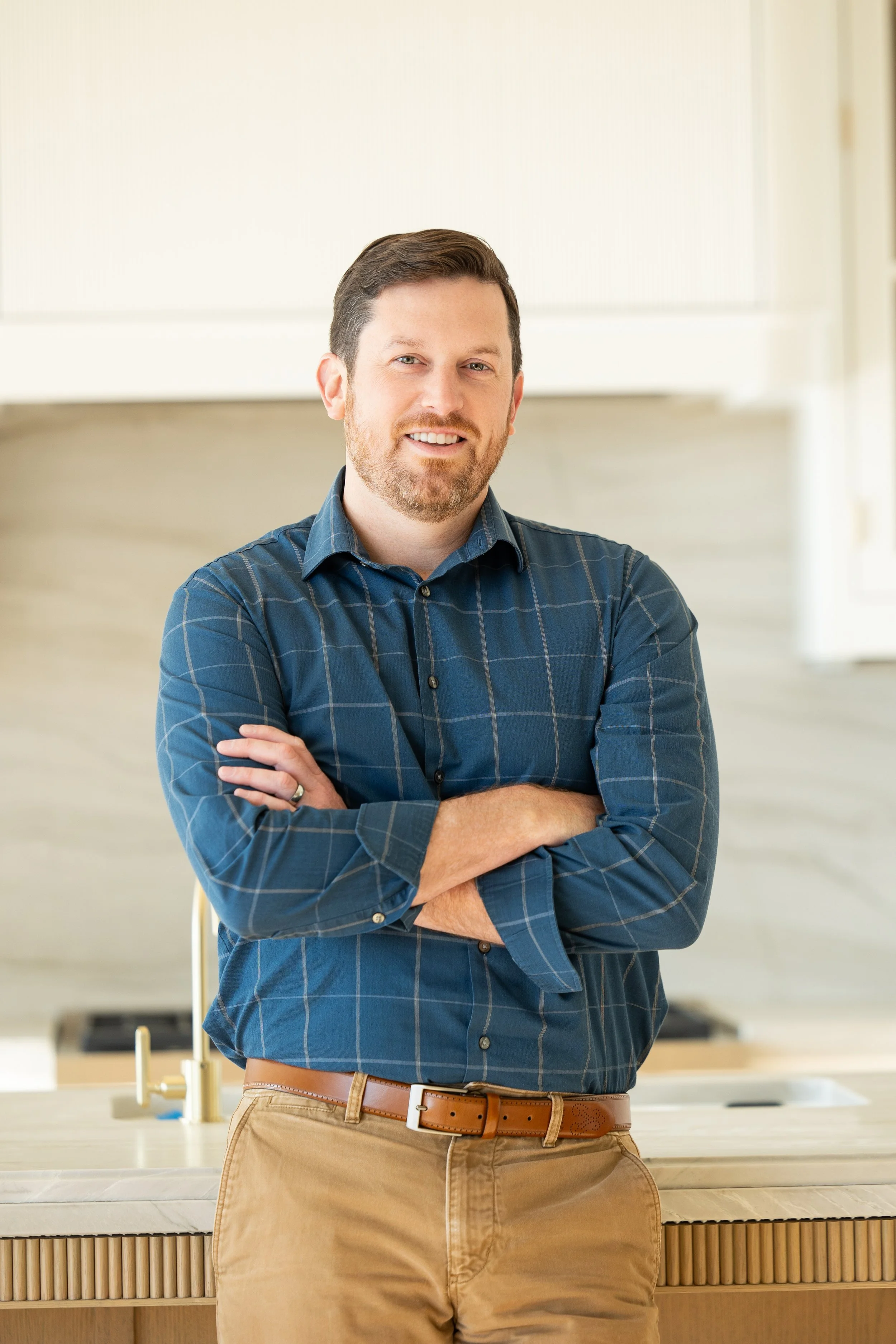 Man drawing home design plans on a desk in an office setting.