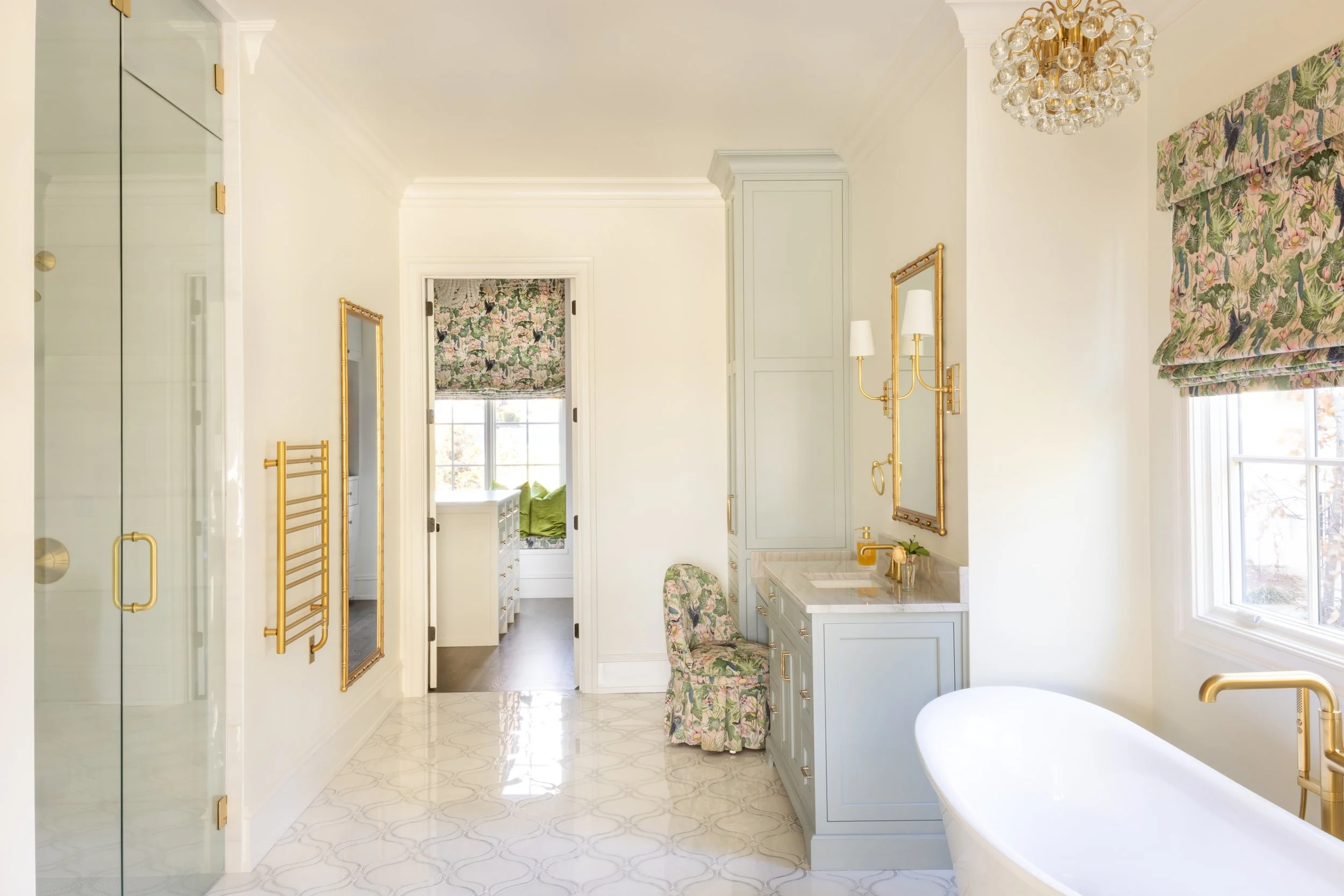 Bathroom interior of a luxury custom home by Will Johnson Building Company in the Triangle NC featuring freestanding tub, glass shower, brass fixtures, and bright natural light