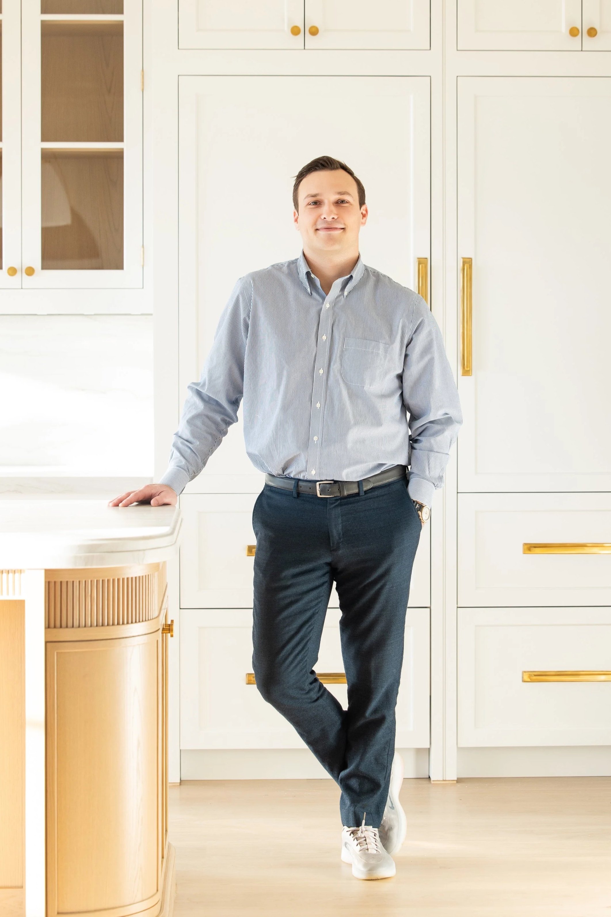 Person sitting at an office desk with a computer, smiling at the camera.