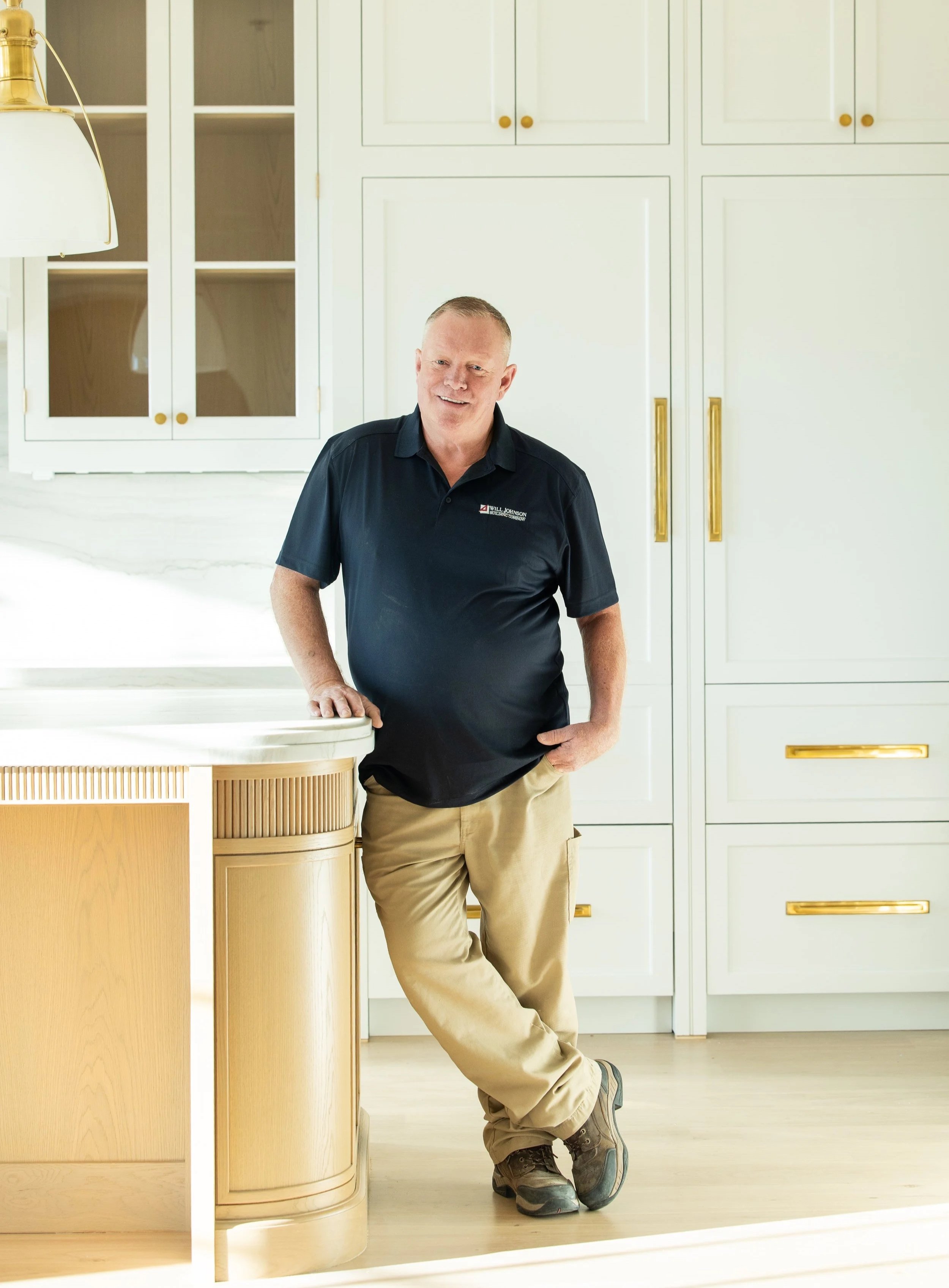 Man standing beside a white van with "Will Johnson Building Company" logo and phone number.