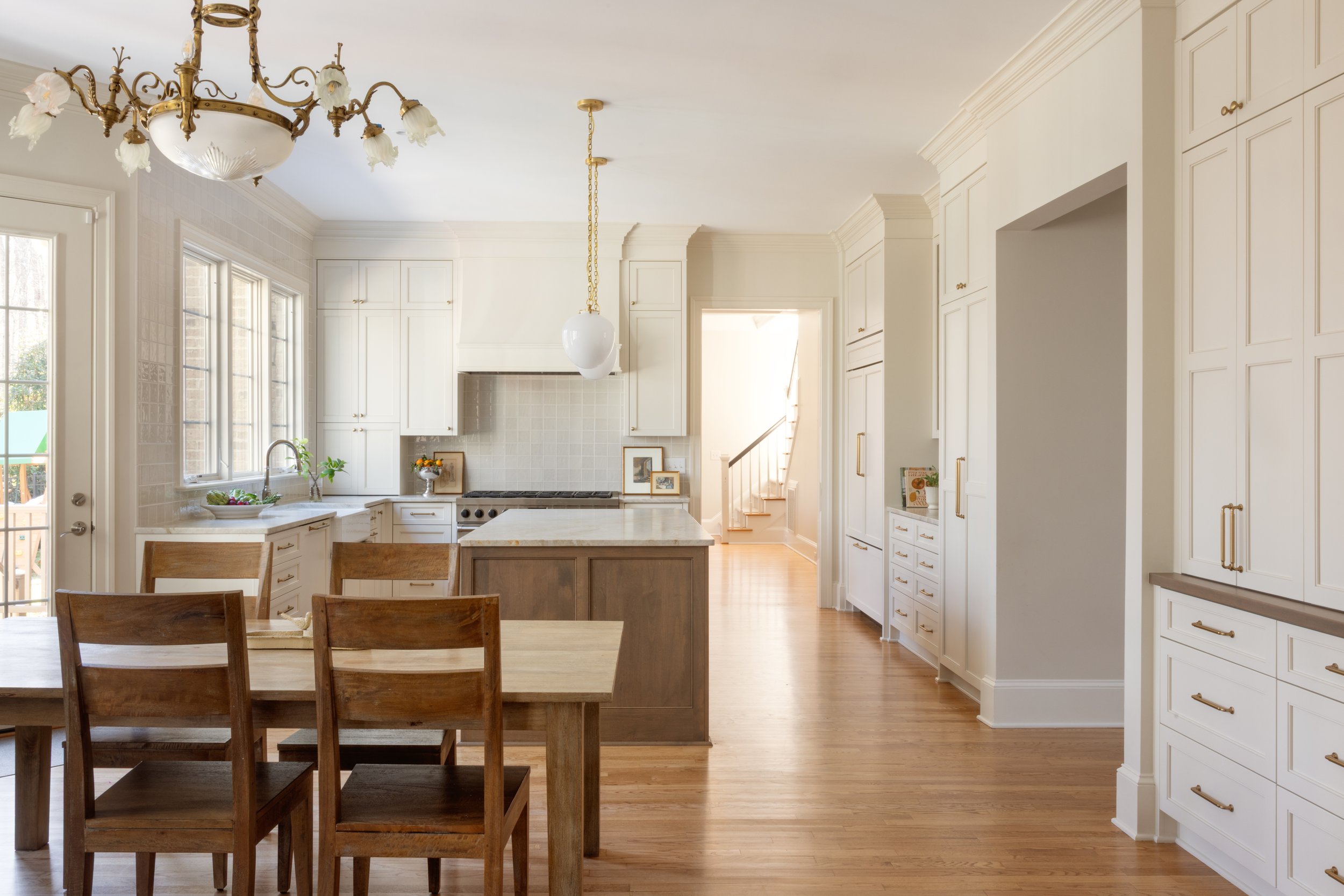 Modern transitional custom kitchen with white cabinetry, large island, and natural light