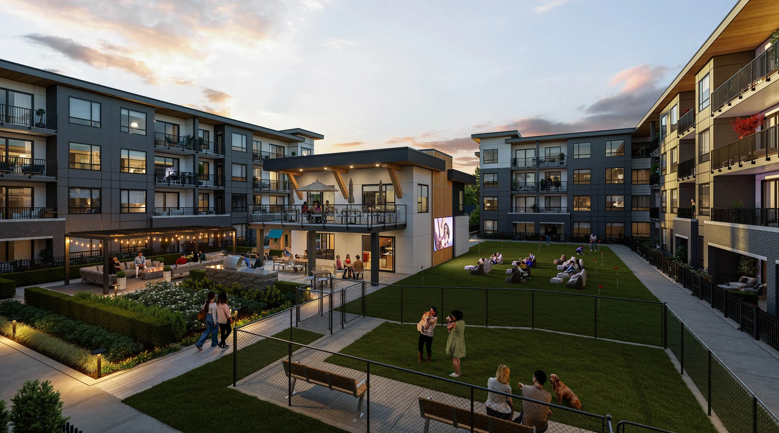 Courtyard lawn between the buildings at dusk, with people on benches and the lit amenity building at one end