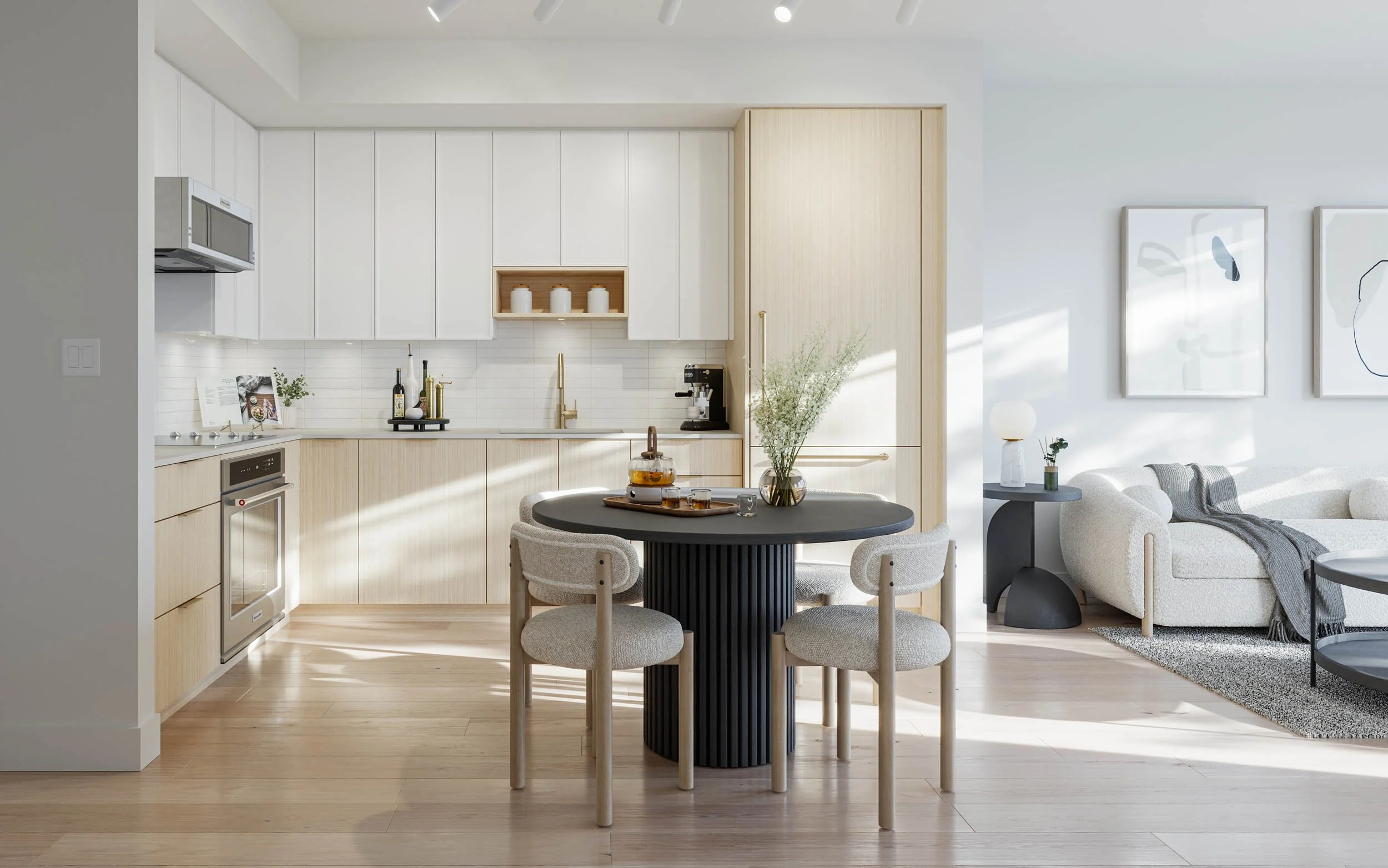 Suite kitchen and living area in the sand scheme, with white upper cabinets, pale oak lower cabinets, a light oak floor and a dark round dining table