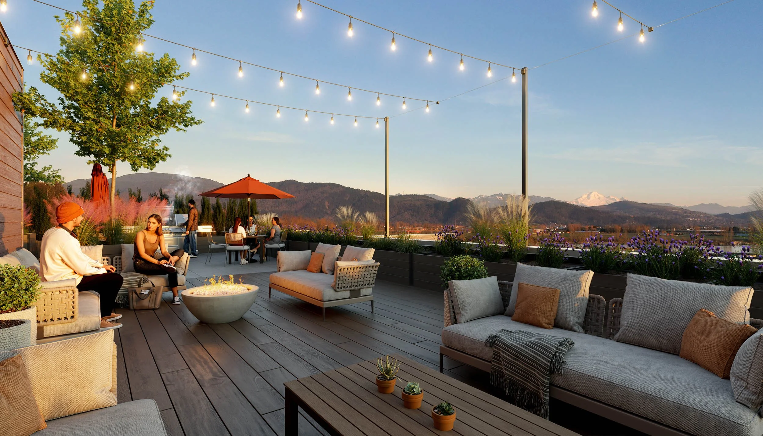 Rooftop terrace at dusk with festoon lighting, a fire table, lounge seating and planters, looking out to distant mountains