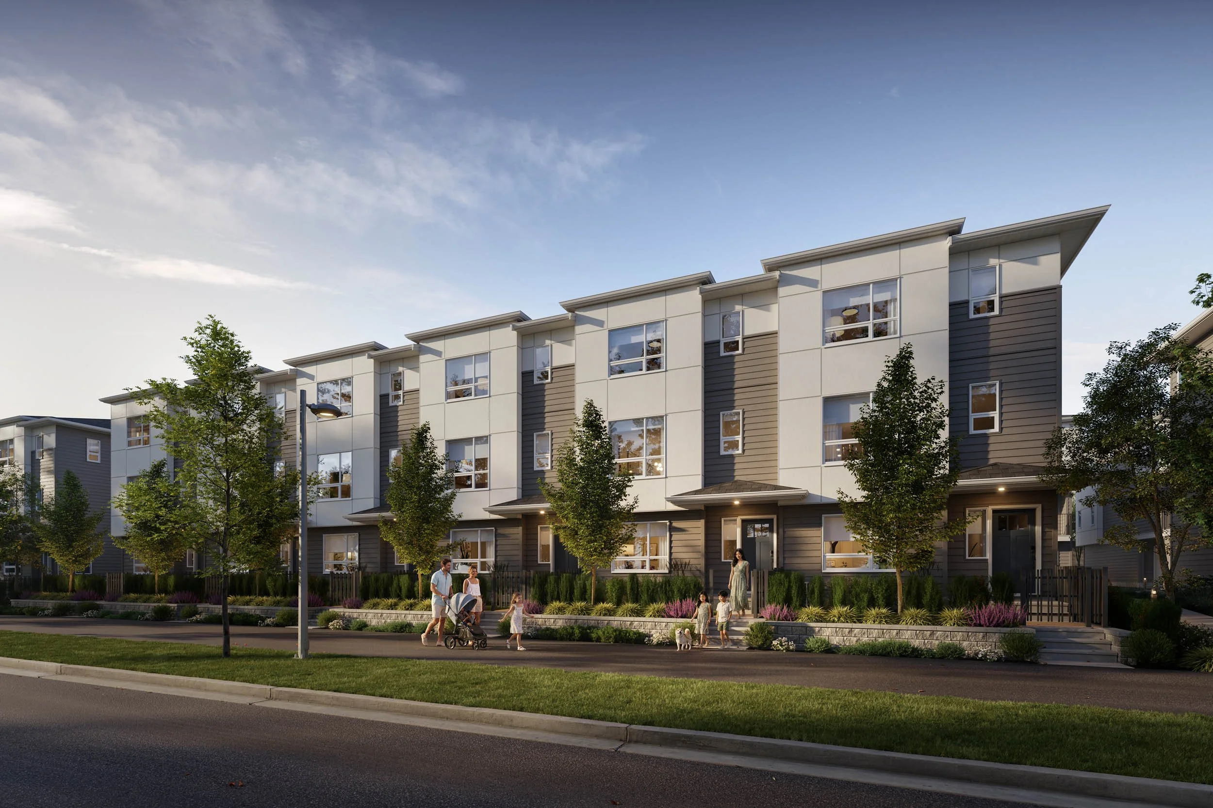 Row of three-storey townhomes along a street in late light, with young boulevard trees, individual entries and people walking on the sidewalk