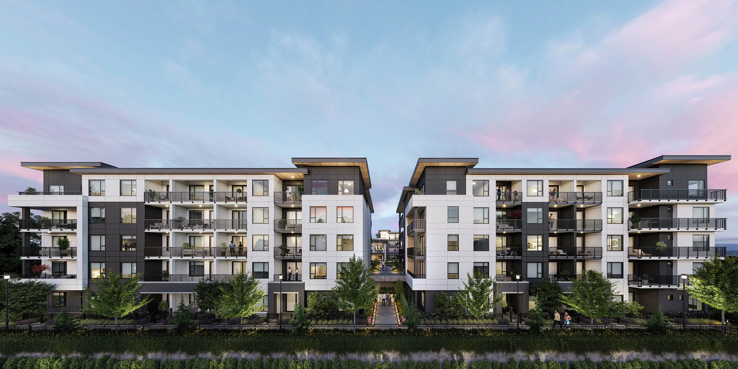 Two residential buildings facing each other across a planted channel under a pink sunset sky