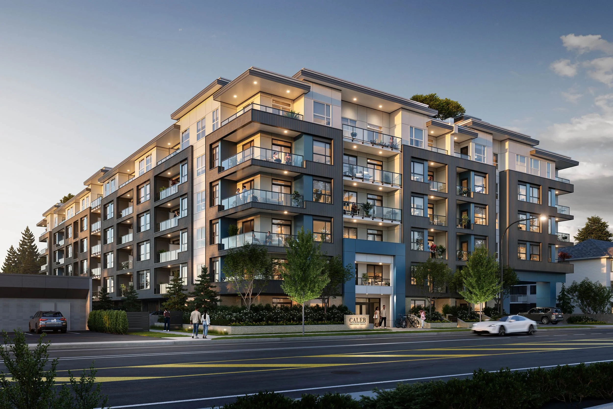 Six-storey condominium lit at dusk along a main road, with signage at street level