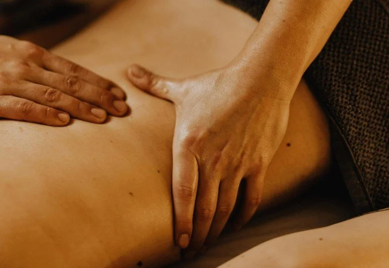 Une personne donne un massage sur le dos d'une autre personne.