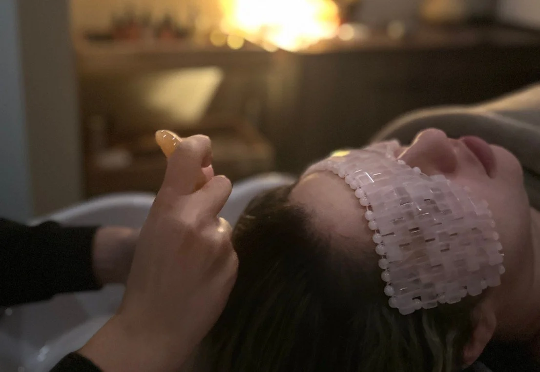 Une personne allongée dans un lit avec une bande adhésive sur le visage, recevant probablement des soins médicaux ou en convalescence.