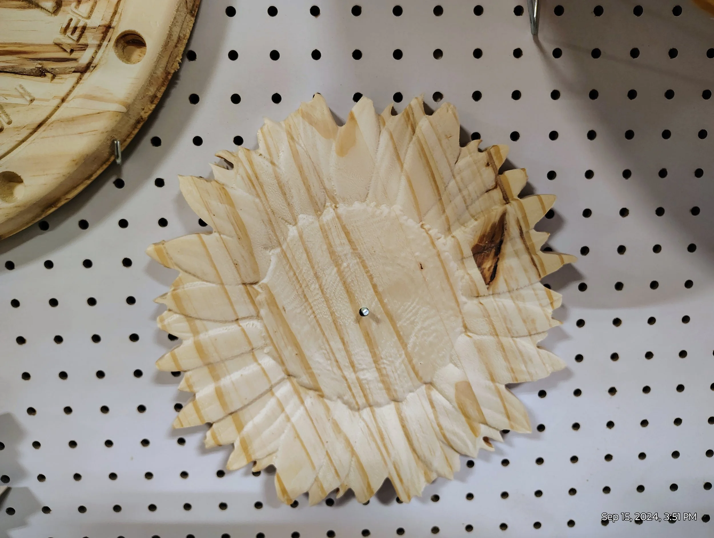 wooden sunflower wall decoration on pegboard display