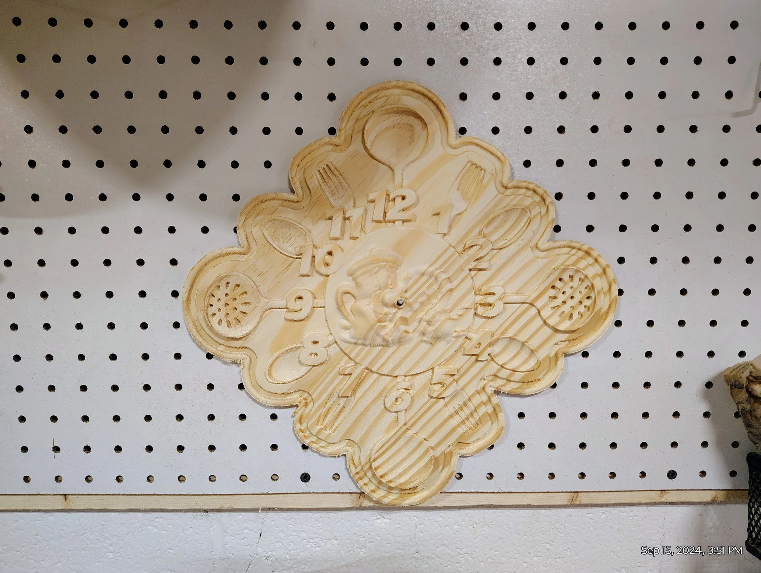 Wooden kitchen-themed clock on pegboard wall