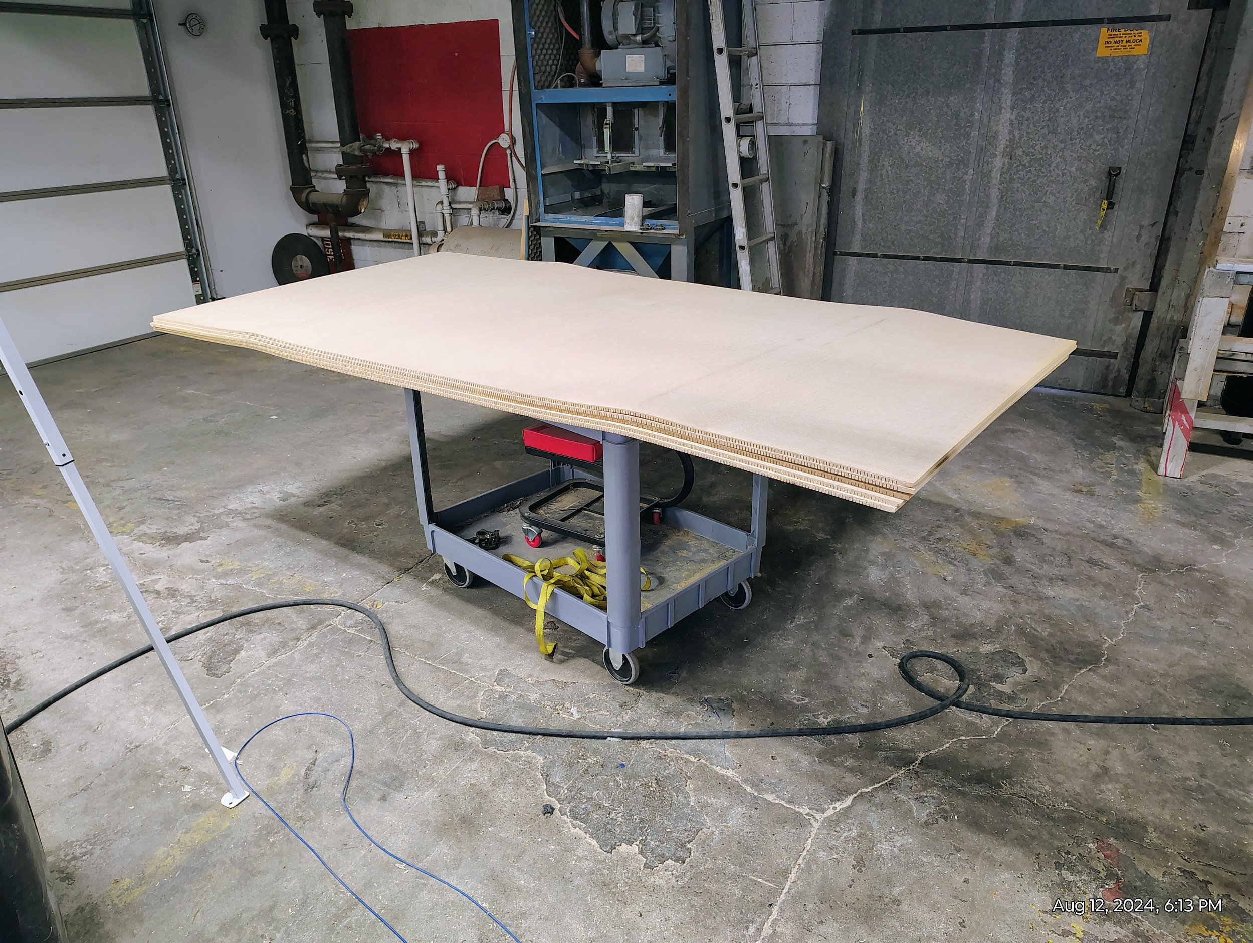 Large wooden panels on a wheeled cart in a workshop.