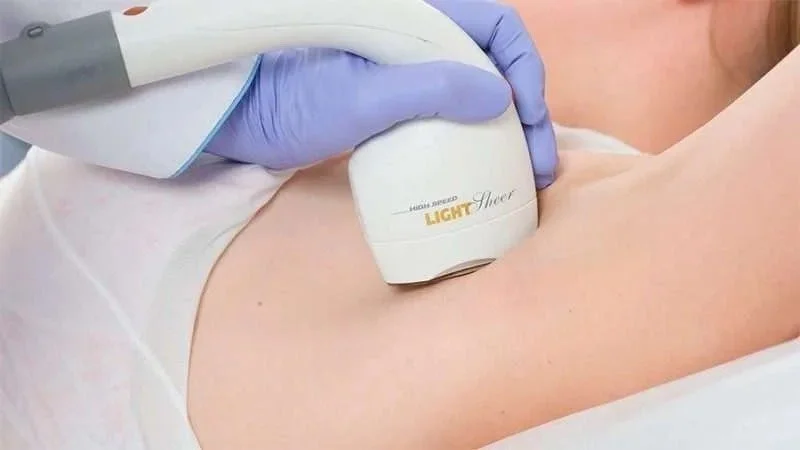 Medical professional using light therapy device on patient's skin