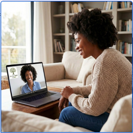 Woman smiling on a video call with her laptop in a cozy living room.