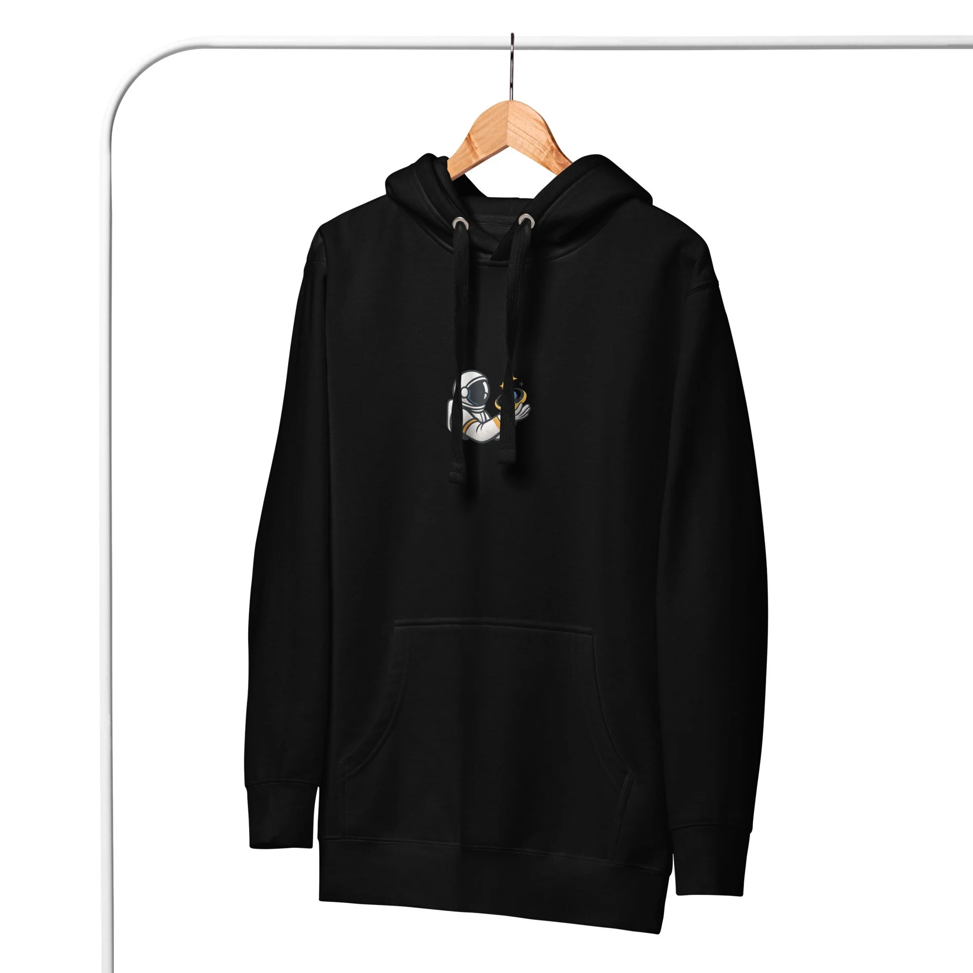 Black “Universe Holder” Evolvv hoodie hanging on wooden hanger, showing astronaut holding a galaxy.