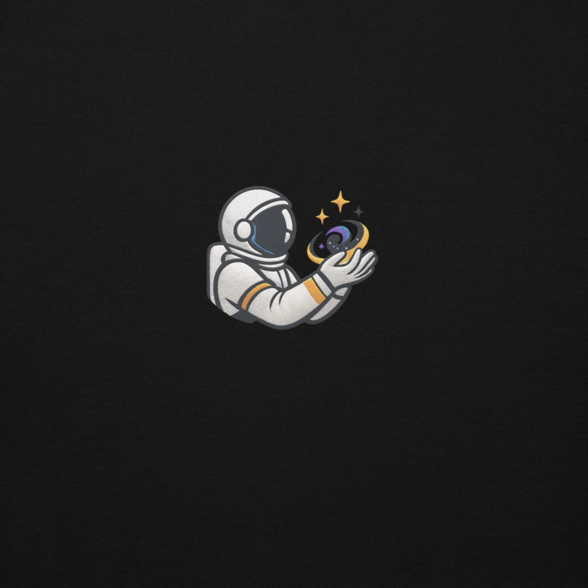 Close-up of the astronaut holding a tiny galaxy on the front of the black Evolvv “Universe Holder” hoodie.