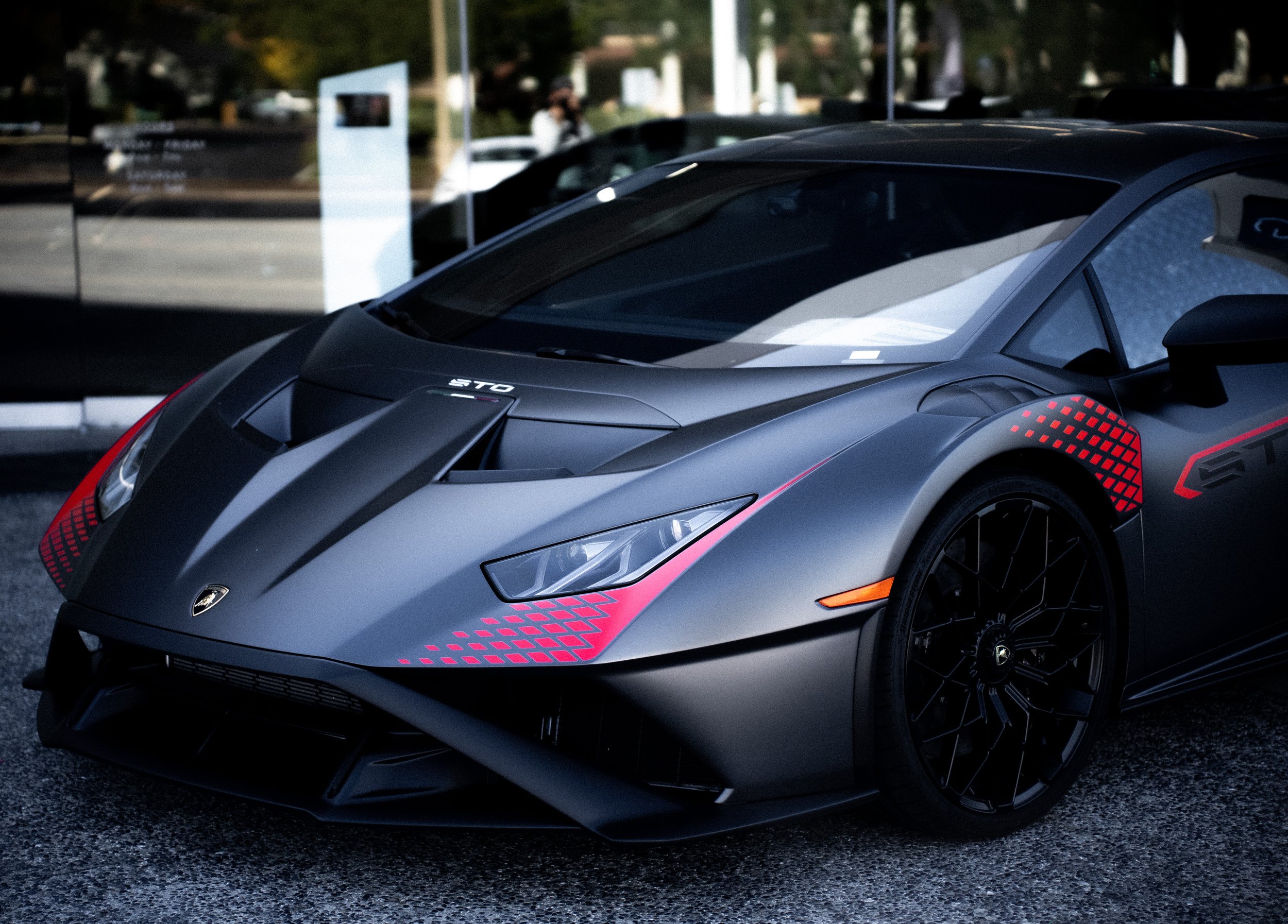 Black Lamborghini sports car with red accents parked outside