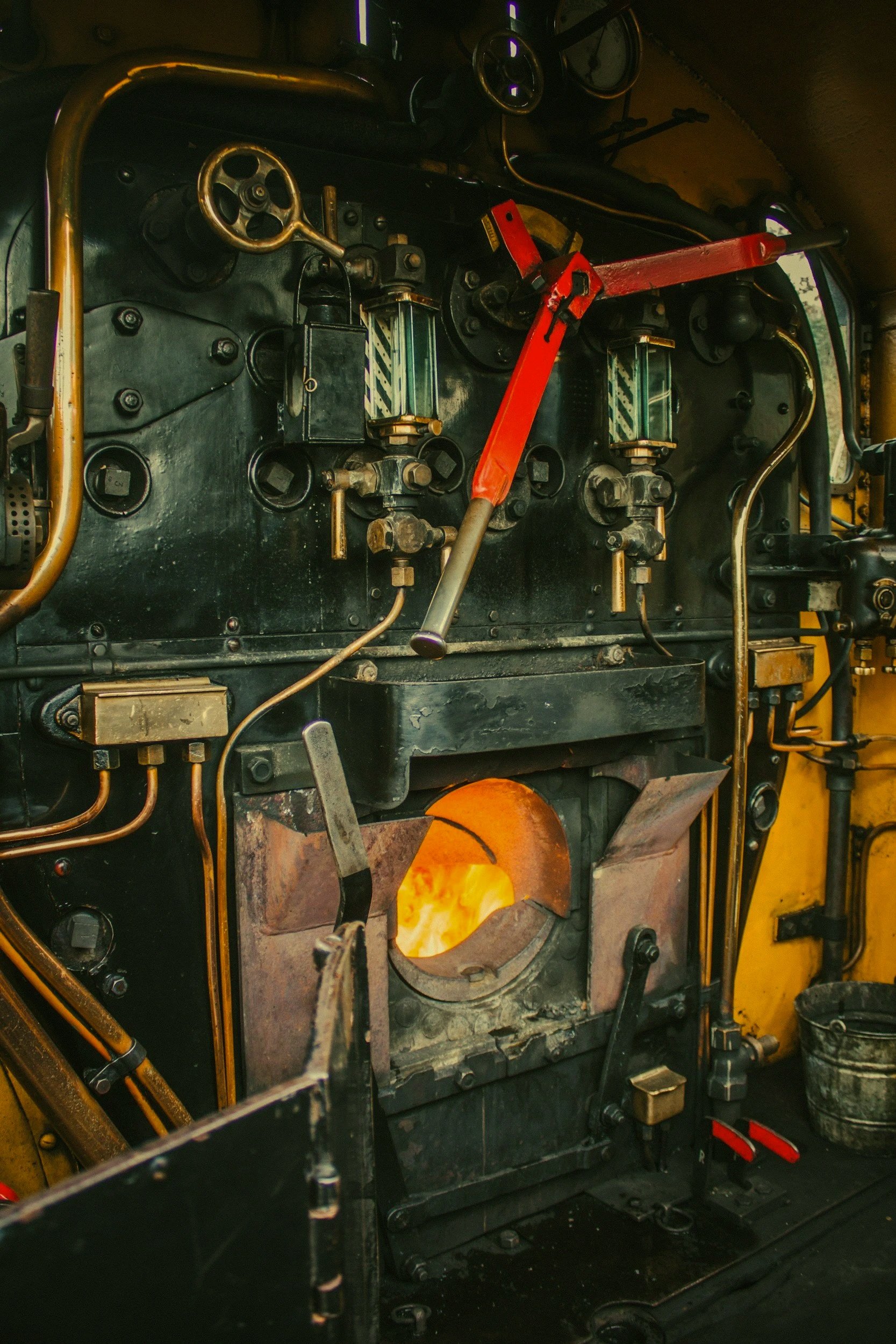 A close-up of a vintage steam locomotive's interior showing the boiler, firebox, and various mechanical components.
