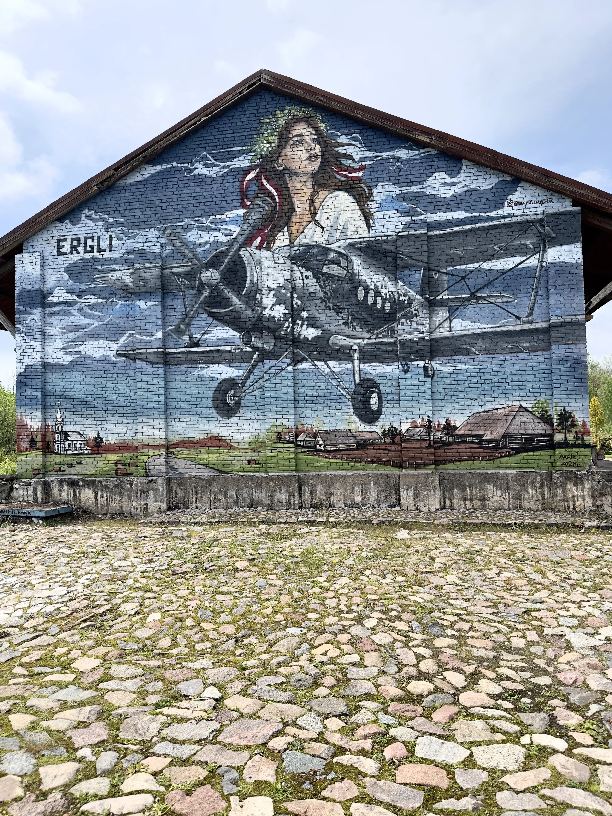 Mural of a Latvian Air Force aircraft on the historic railway station building in Ērgļi, Latvia