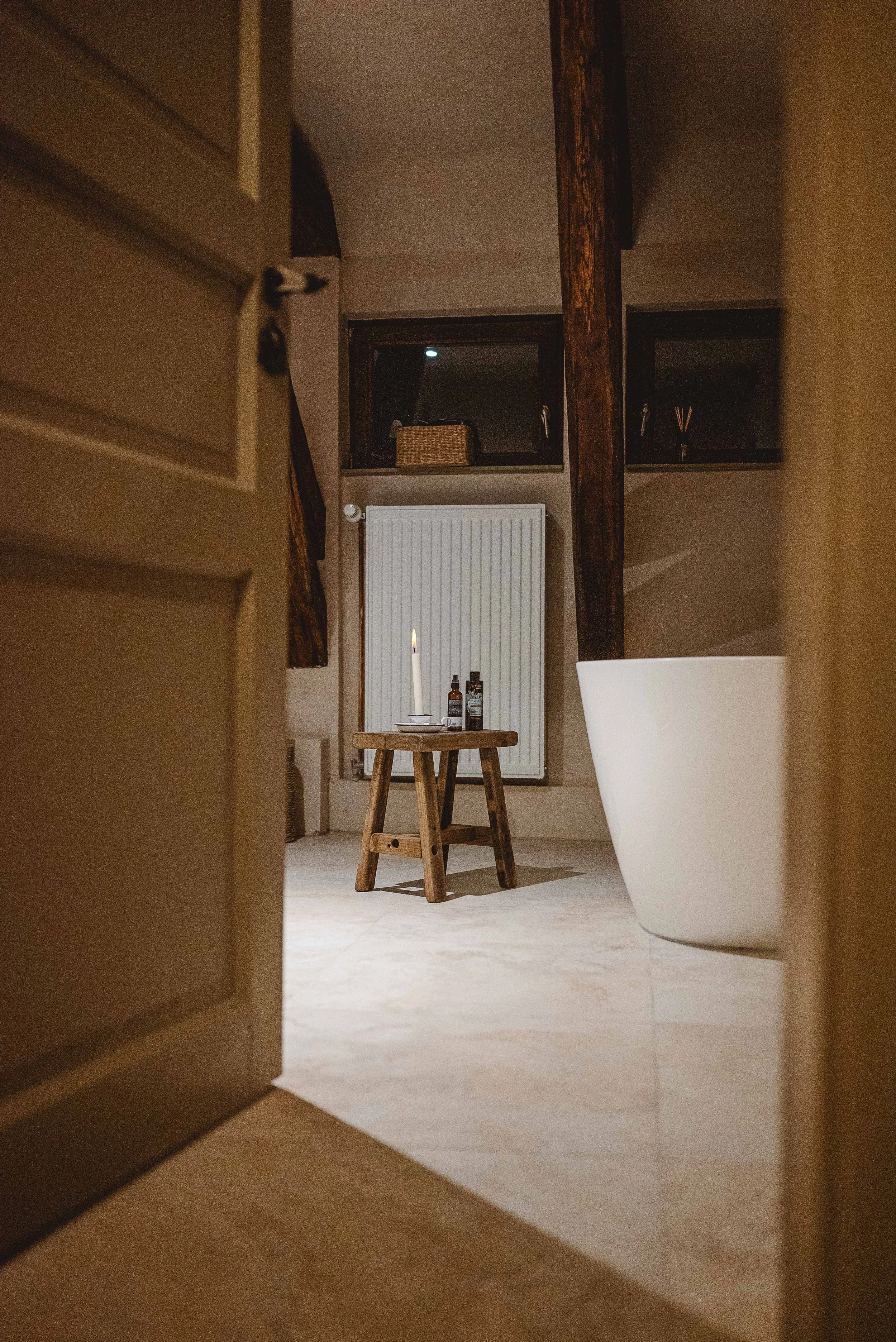 Foto von einem Badezimmer mit brennender Kerze und Badewanne in einer Ferienunterkunft im harz