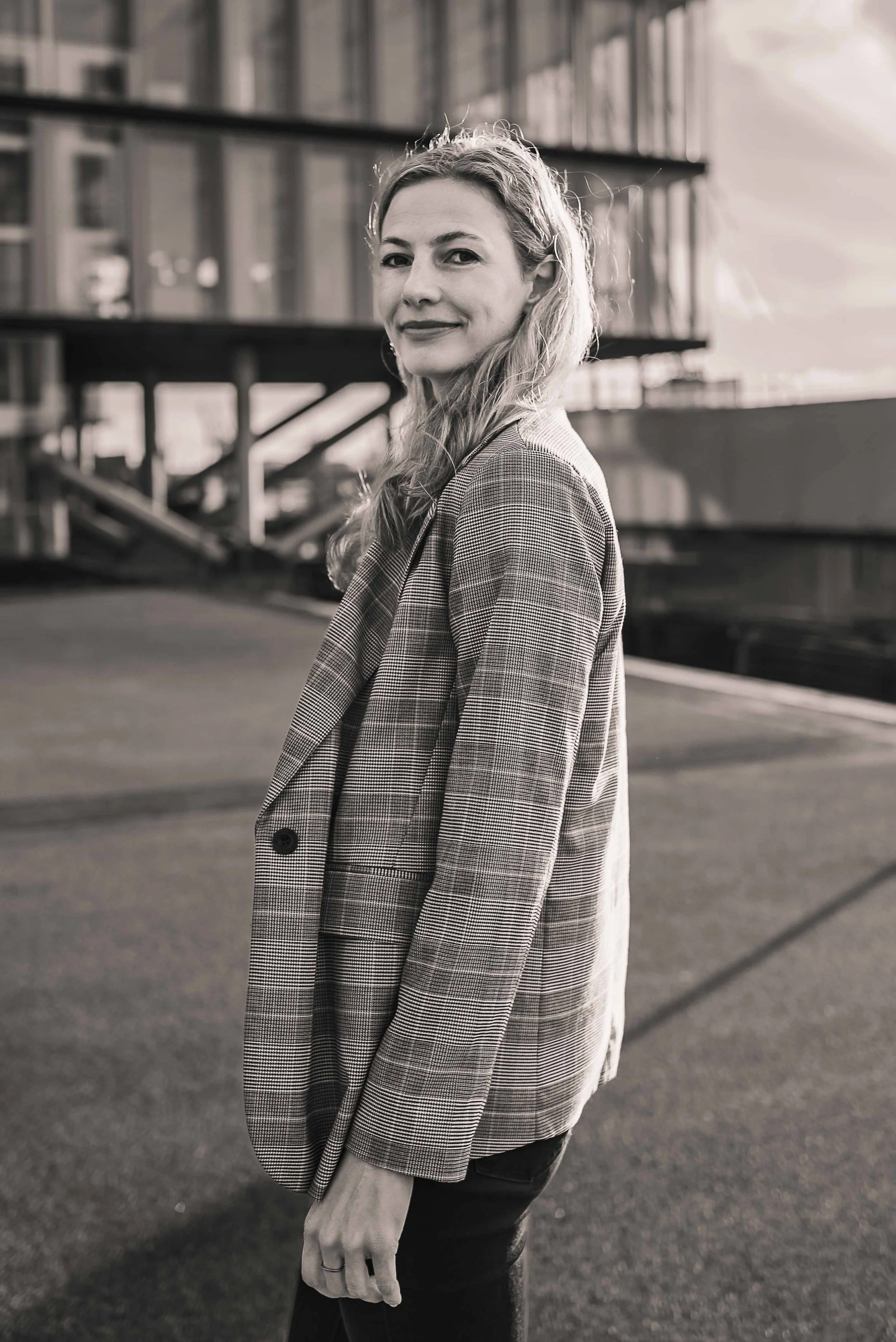 Sympathisches Business Portrait einer Frau in Hamburg, natürlich lächelnd vor hellem Hintergrund.