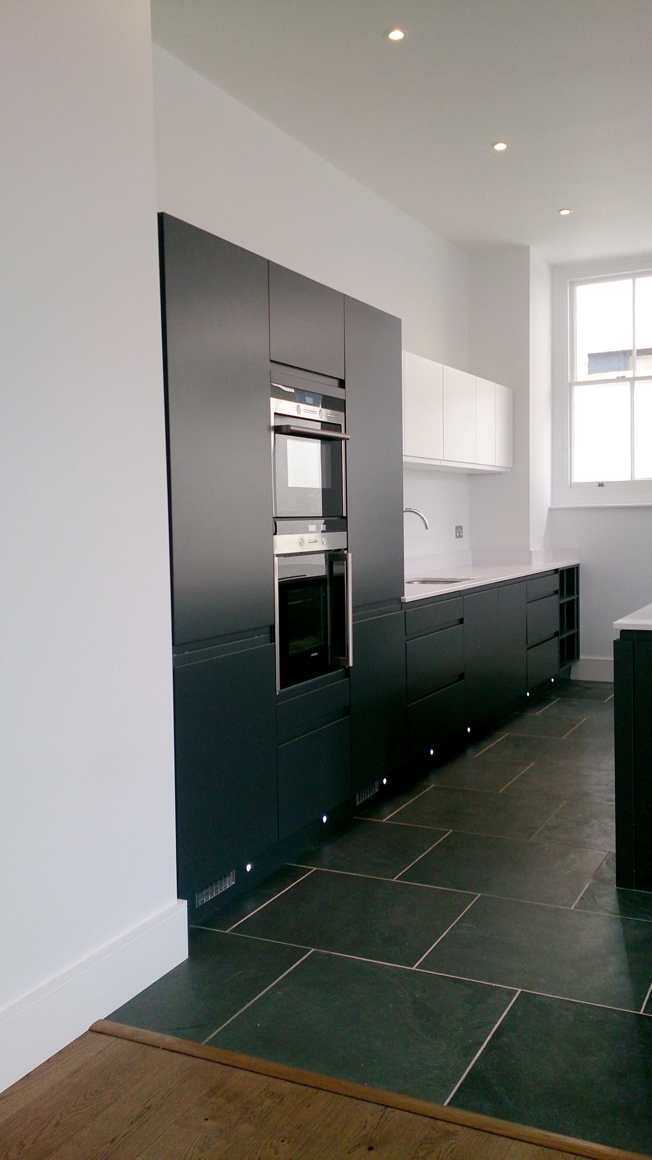 Mortimer Hall grade 2* listed building internal contemporary black kitchen cabinetry with black floor tiles.jpg