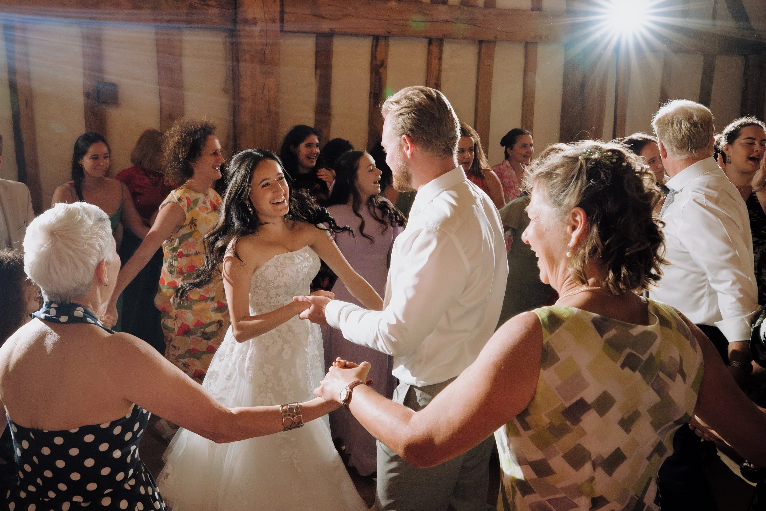 Couple dancing at a wedding reception with guests in the background.