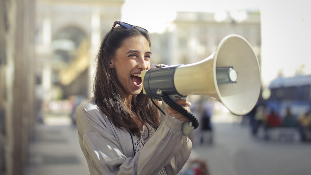 Woman with a megaphone proclaims brand message without greenhushing