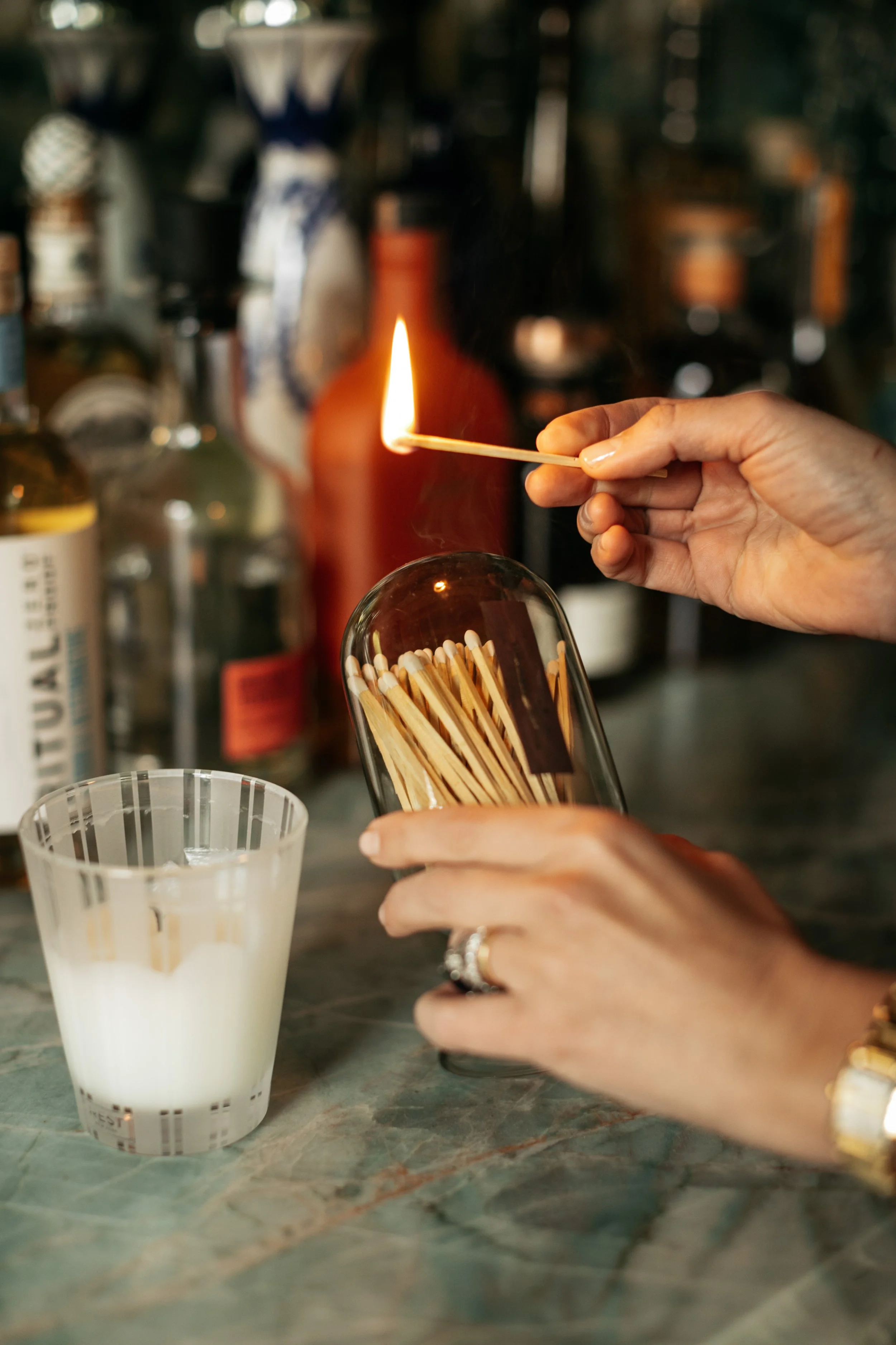 woman lighting a match using a match cloche