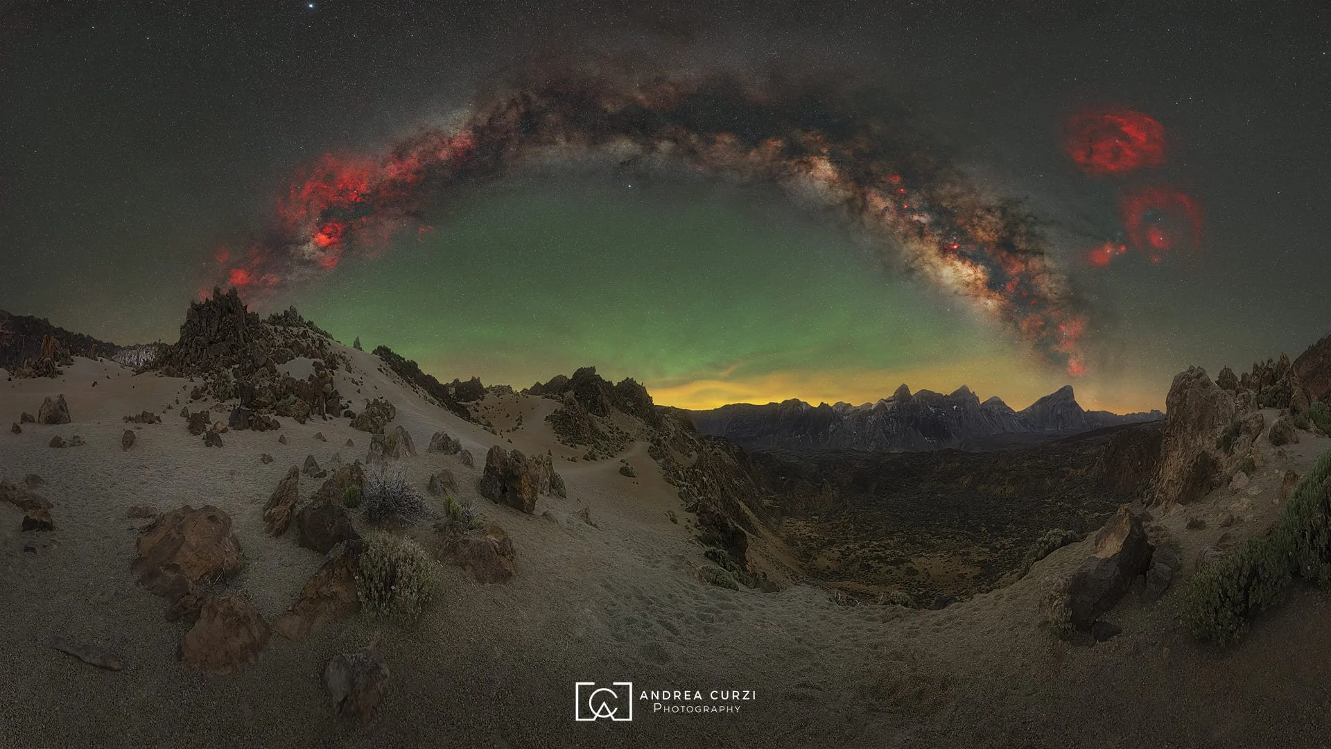 Paesaggio notturno di Minas of San Jose con cielo stellato, l'arco della via lattea estiva con l'airglow, con rocce e sabbia sul primo piano. Scattata durante un viaggio fotografico a Tenerife sul Parco Nazionale del Teide di Andrea Curzi.