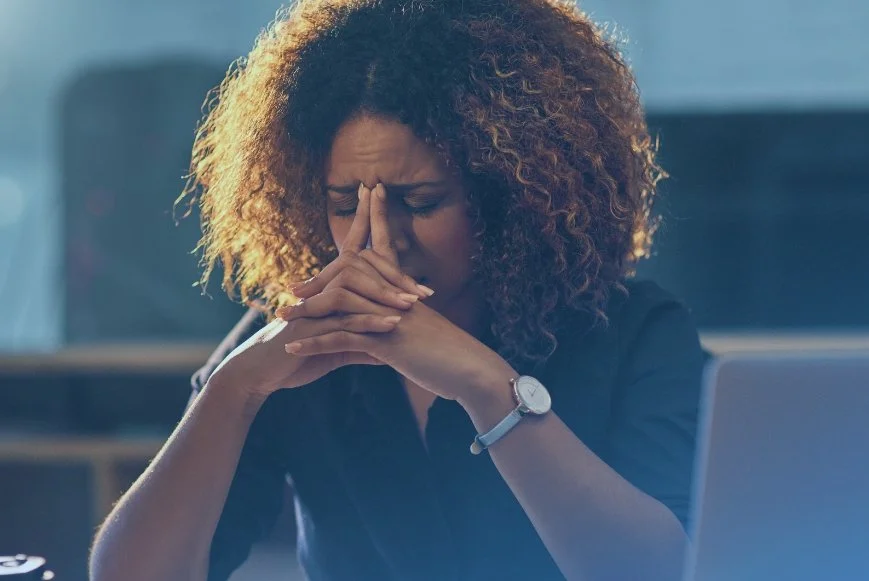 Woman holding her face looking exhausted representing Iron levels and metabolic testing in Houston TX