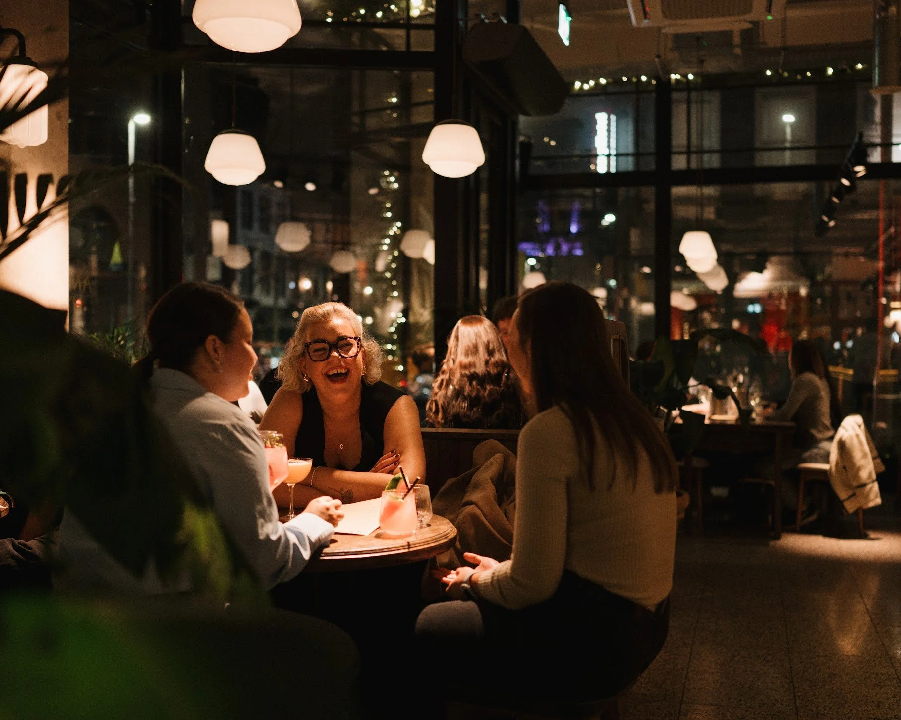 Friends enjoying cocktails and pizza at Amelia Hall in Belfast.