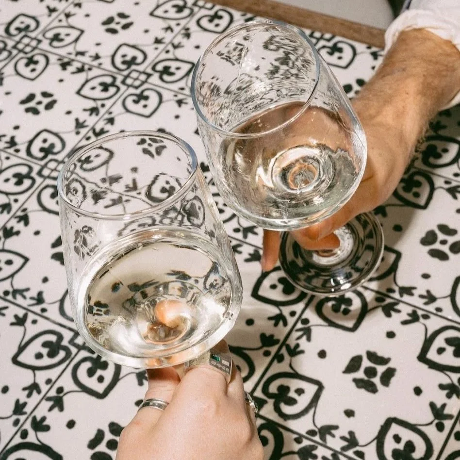 Late night drinks. Guests raising glasses of white wine at Amelia Hall, a bar on Howard Street in Belfast city centre.