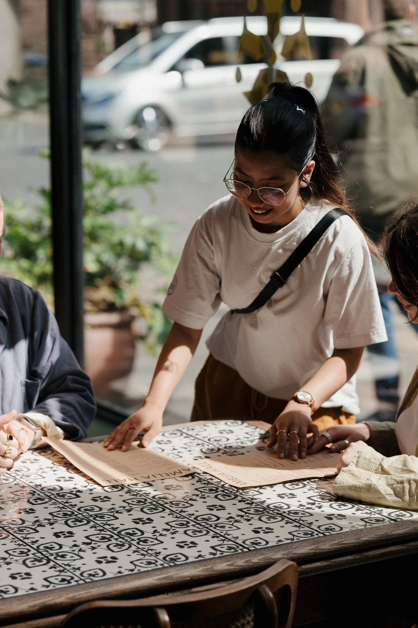 Guests browsing breakfast and brunch menus at a tiled table inside Amelia Hall, Belfast.