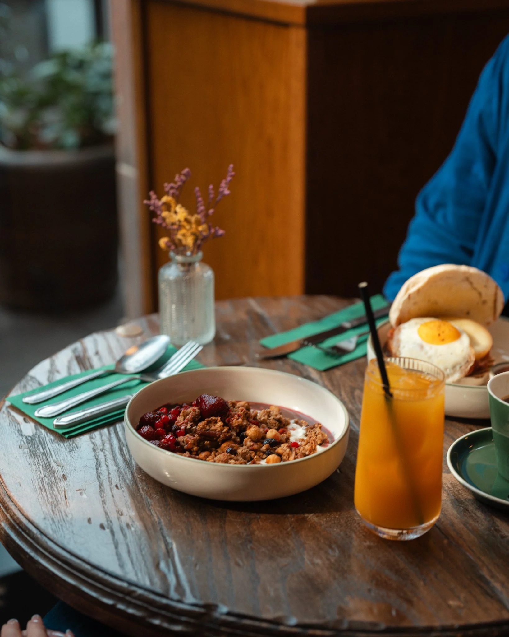 Granola, orange juice and a fried-egg breakfast muffin on a table at Amelia Hall in Belfast city centre.