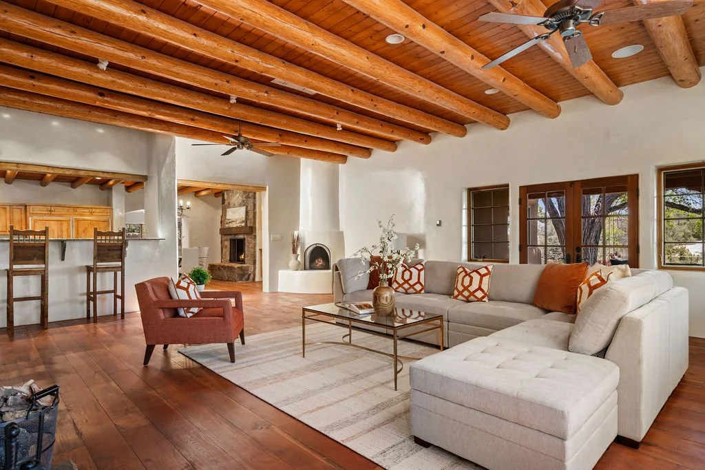 grand living room Santa Fe with vigas and wood floors