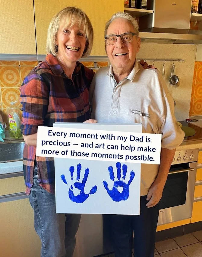 Claudia and her dad, holding a canvas with his hand prints