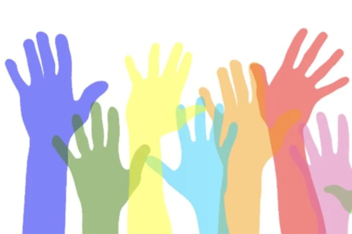 Graphic of raised hands in a rainbow of colors.