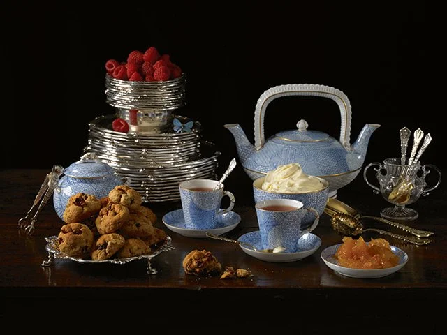 Paulette Tavormina for Sotheby’s — From LUXE: The Art of the Table, a still life in her Old Master style featuring a blue-and-white porcelain tea set with cookies, berries, preserved fruit, and fine silverware.