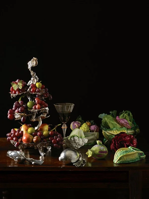 Paulette Tavormina for Sotheby’s — From LUXE: The Art of the Table, a still life featuring a silver fruit stand with grapes and apples, red wine, and assorted vegetables in her signature Old Master style.