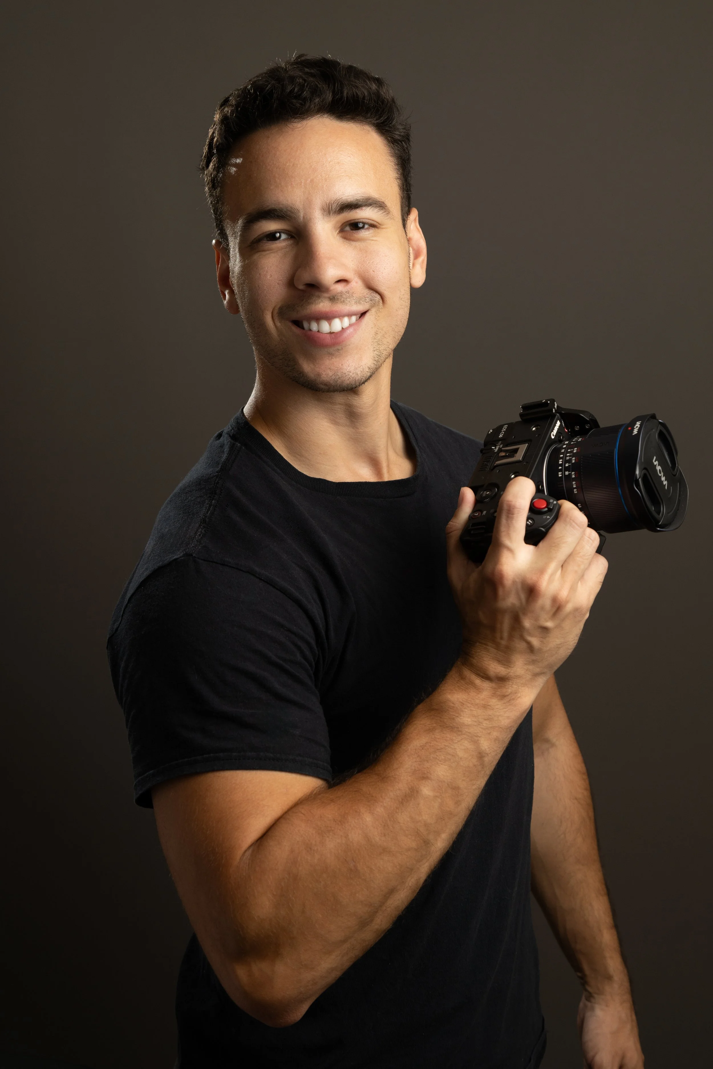 Elijah Anderson, founder of Praedium Pixels, holding a professional camera
