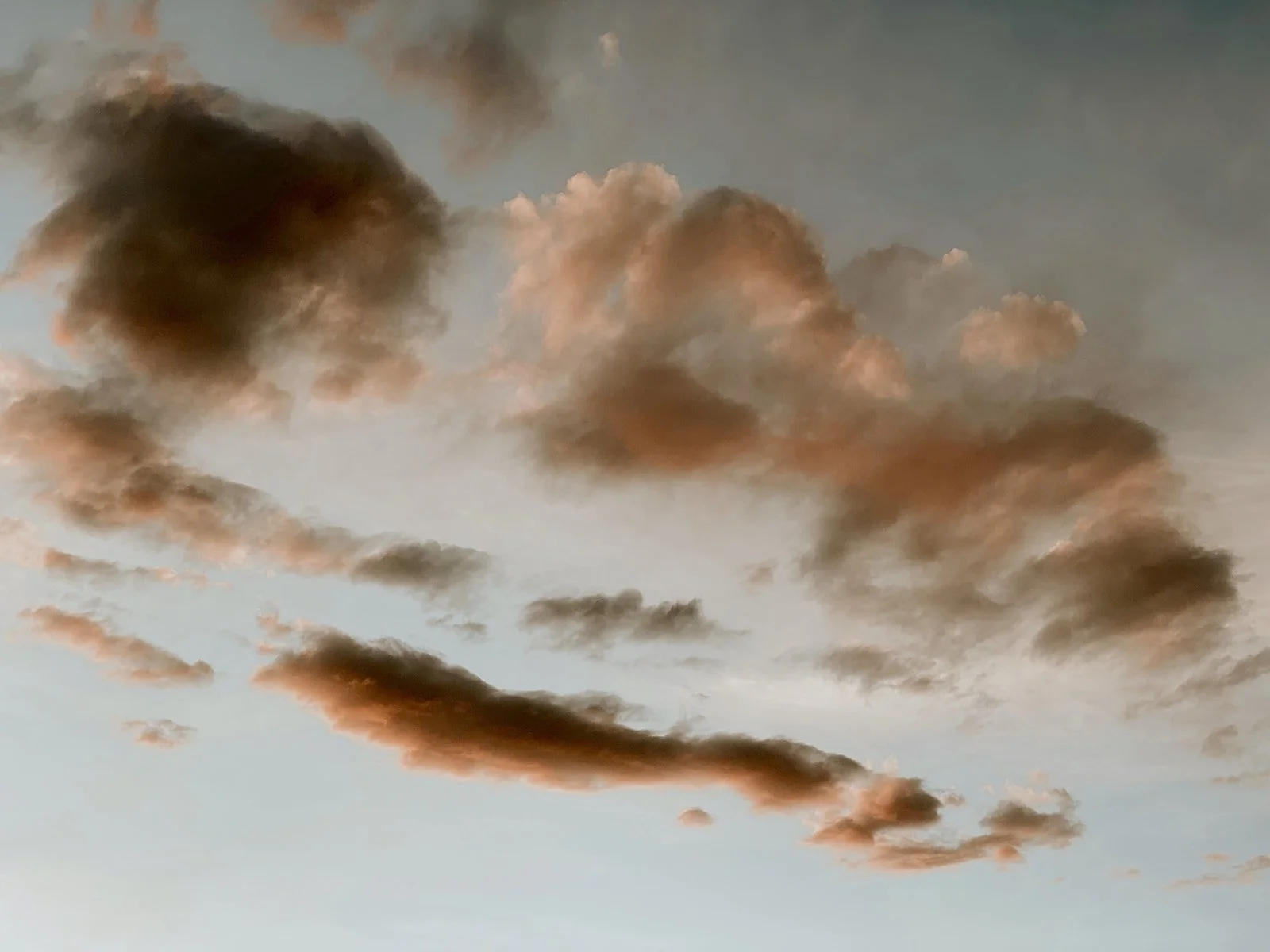 Cloudy sky during sunset with dark and light clouds.