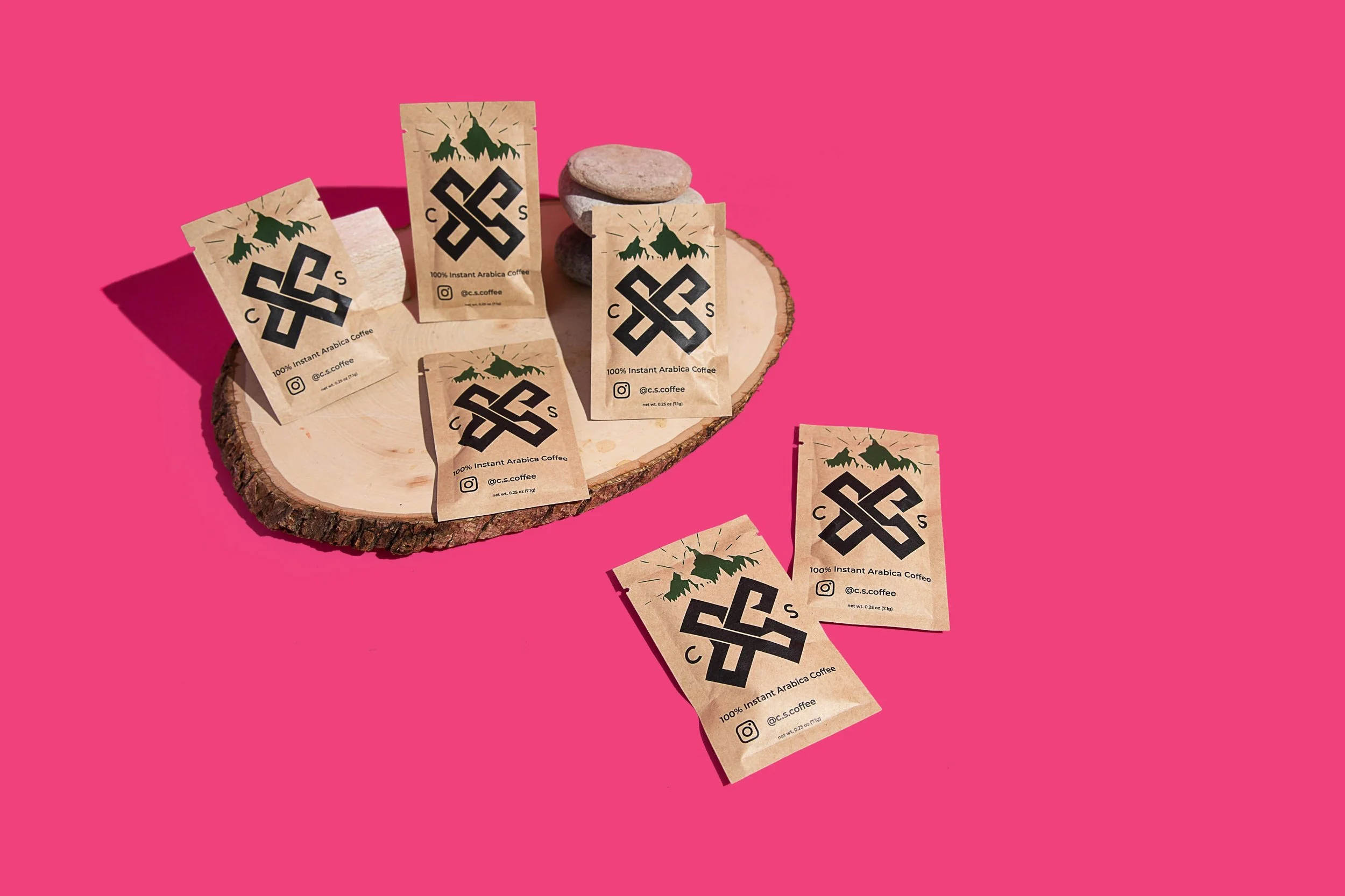 CS Instant Coffee packets in a hot pink studio setting.