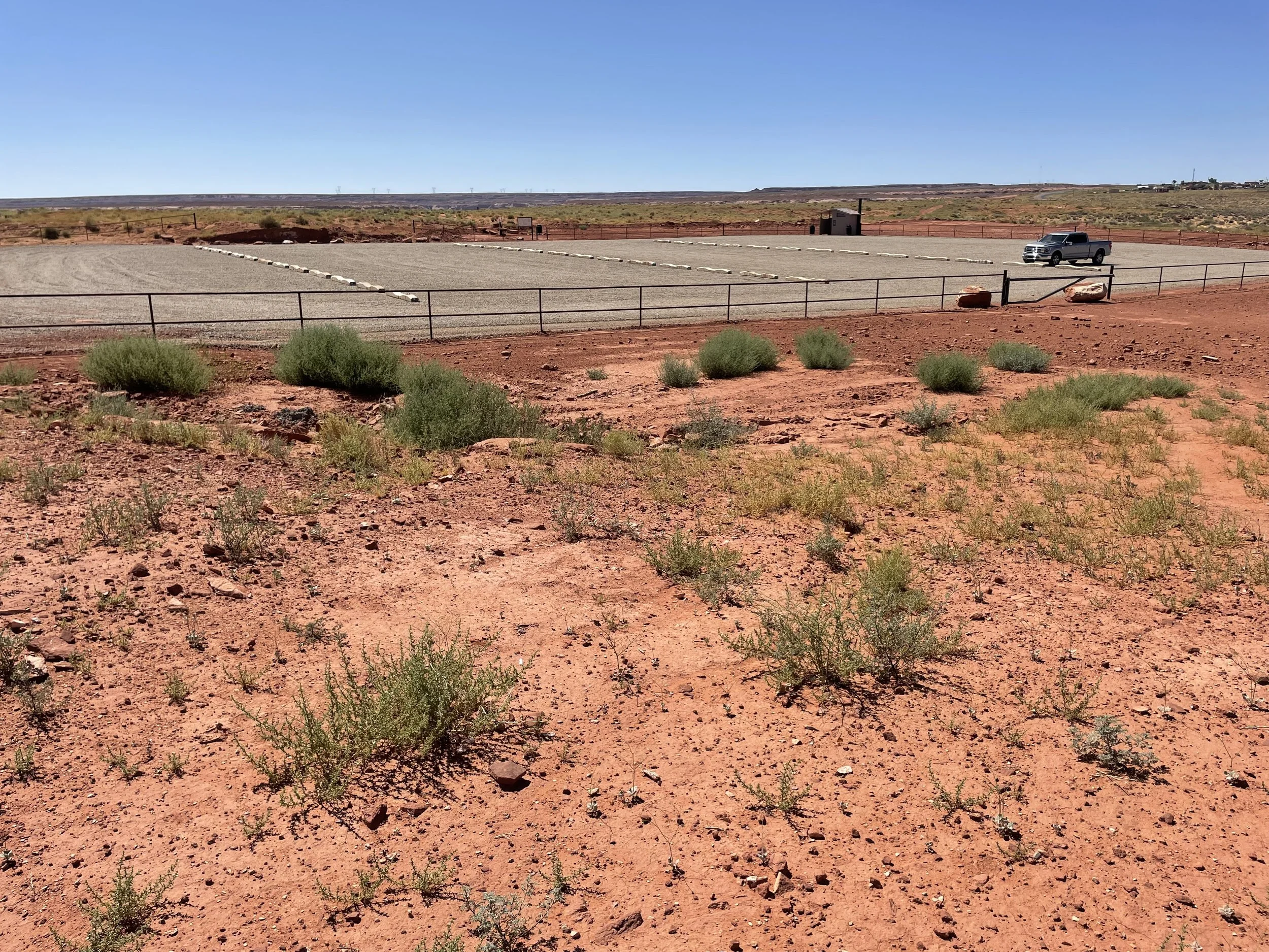 Red Mesa Rim parking lot with vault toilet and a vehicle