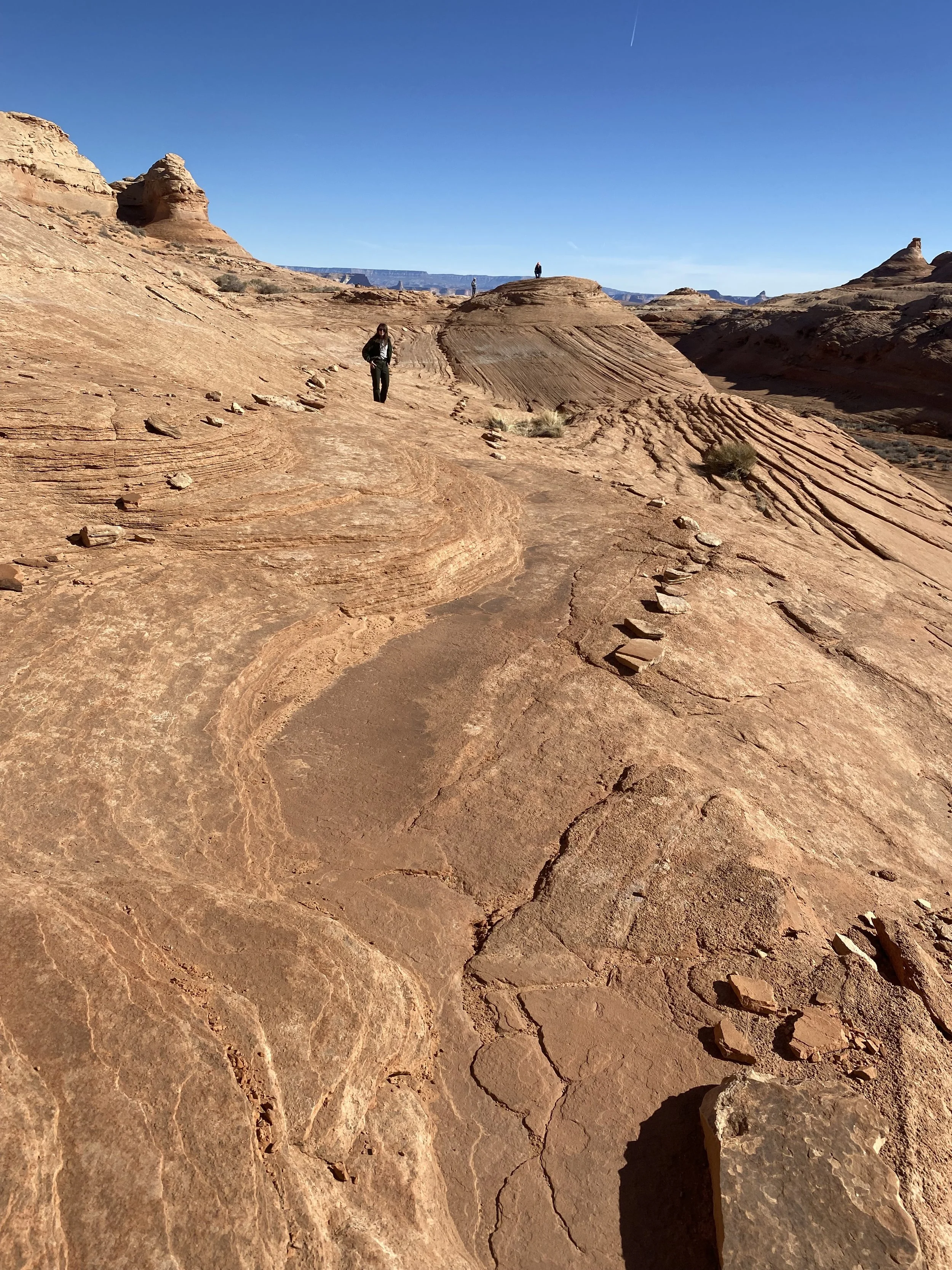 Hikers with small stones delimiting trail along Beehive Trail