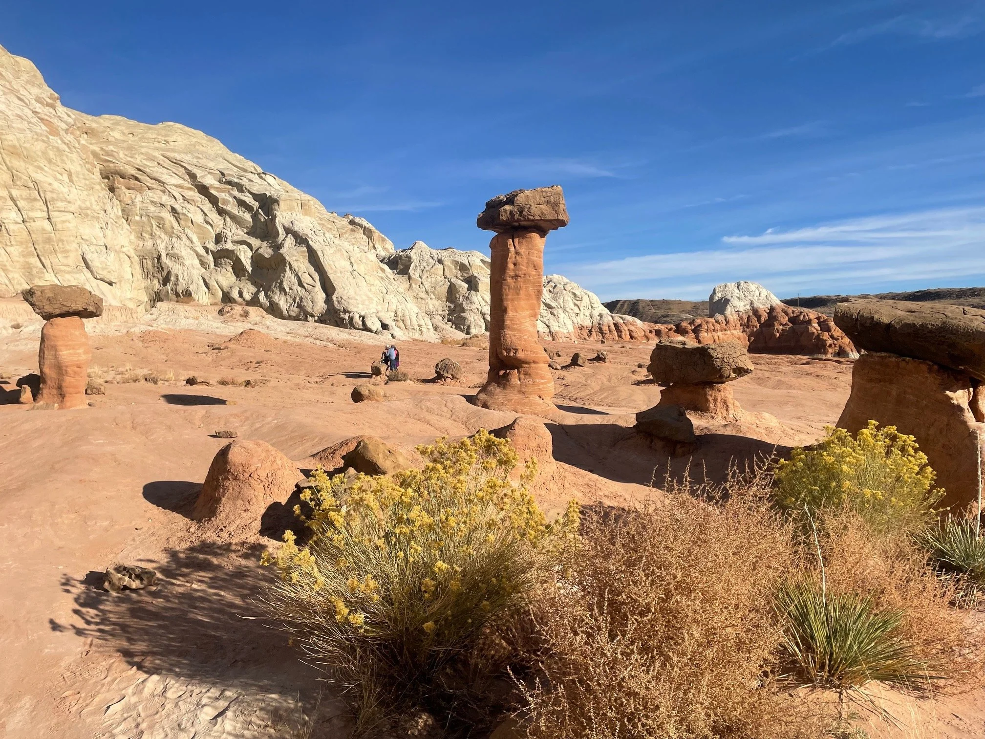 Hikers near sandstone hoodoo on Toadstools Trail