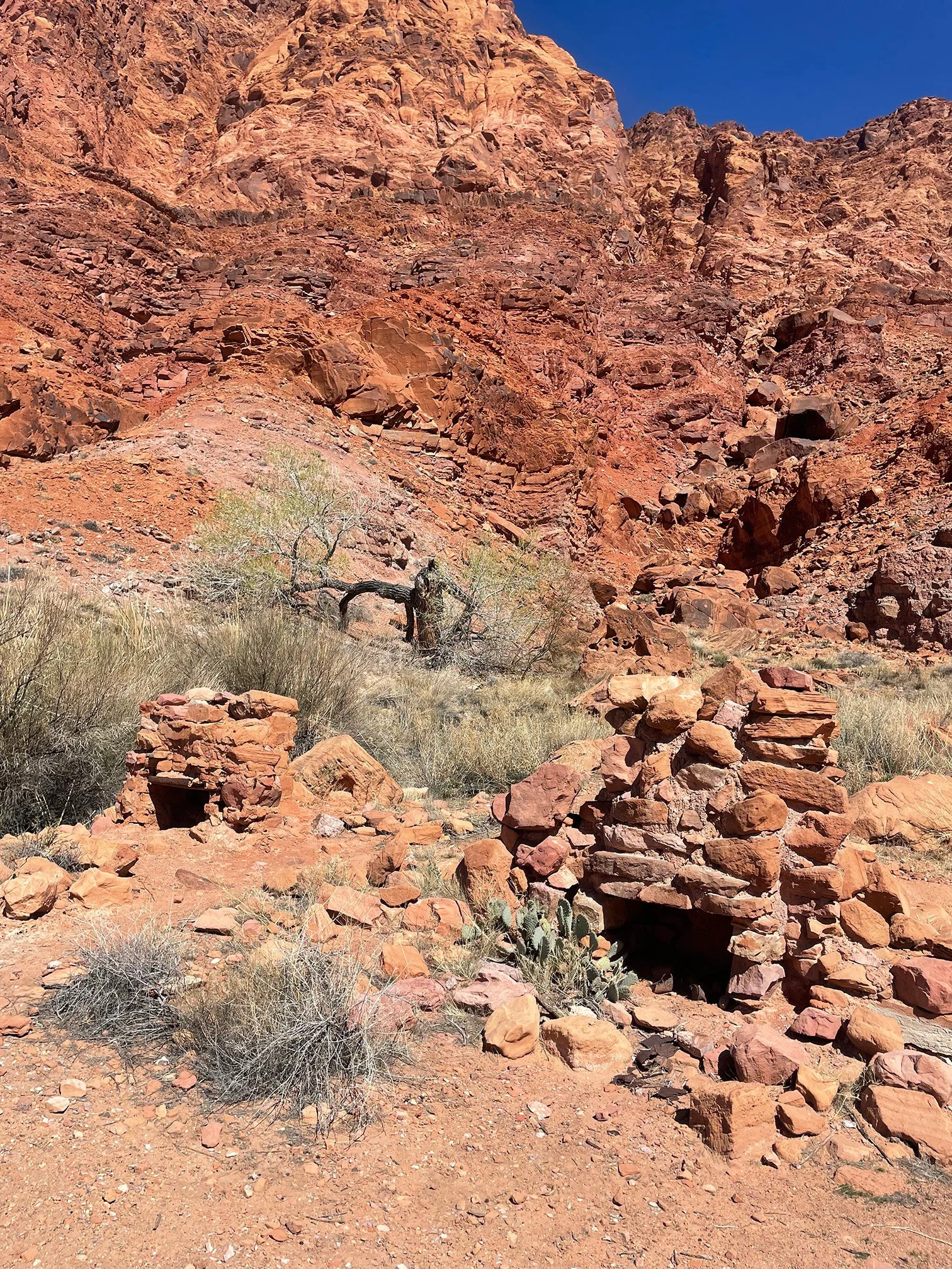 Remains of stone fireplace structures in red rock canyon terrain