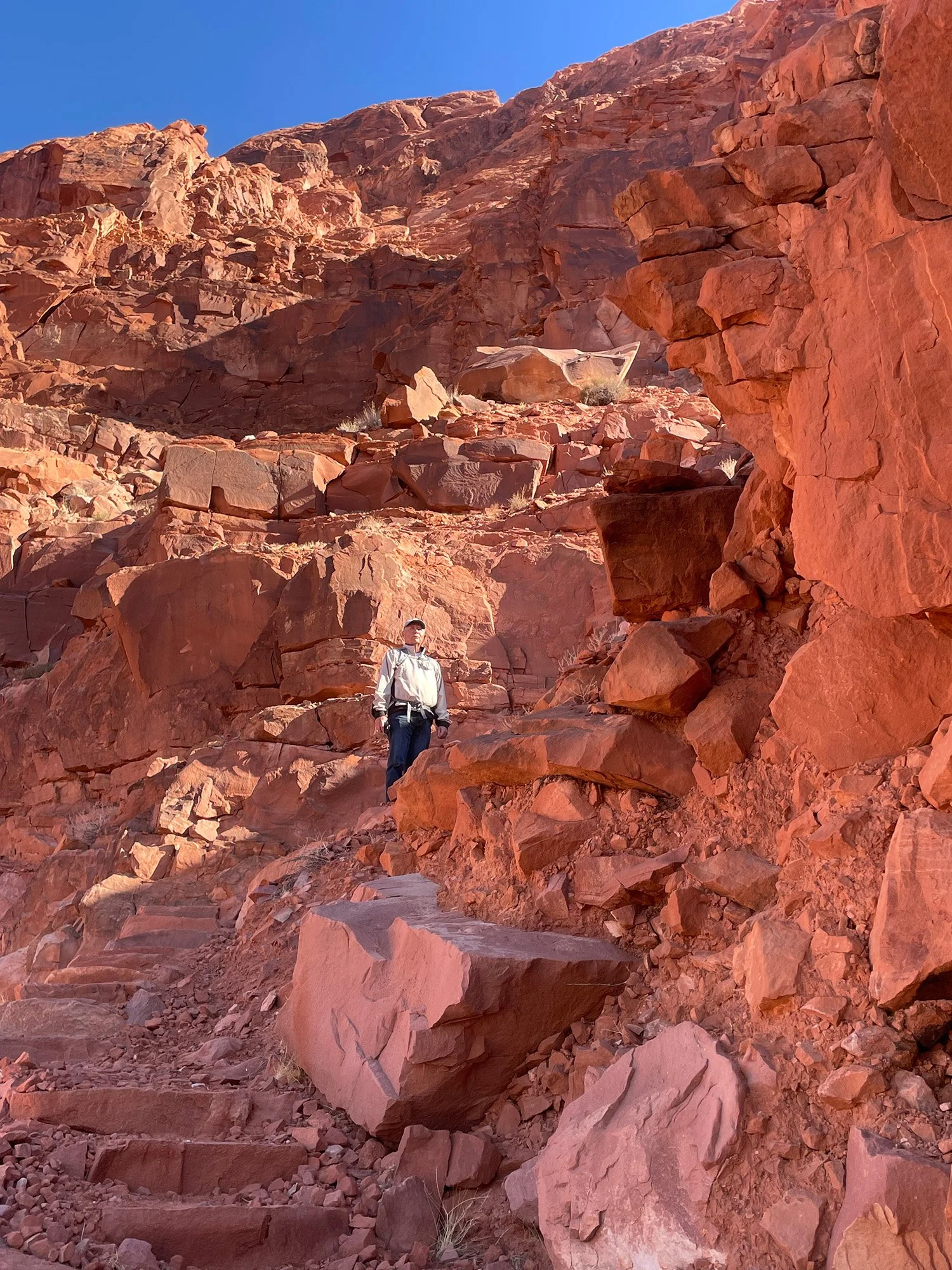A hiker stands on sandstone steps along Spencer Trail